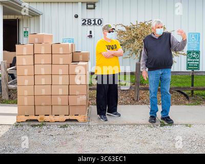 16. Mai 2020, Perry, Iowa, USA: Freiwillige warten auf ein Auto während einer Fahrt durch Foodbank von Iowa in der Crossroads Church in Perry. Die Ernährungsunsicherheit hat in Iowa aufgrund der Pandemie-Abschaltungen in die Höhe getrieben. Die Notkammer in Perry verteilte alle 200 Essensboxen in weniger als 45 Minuten. Der Verbrauch von Notlebensmitteln in der Speisekammer hat sich seit März in Perry mehr als verdoppelt. Die Schweinefleisch verarbeitende Fabrik in Tyson in Perry ist der größte Arbeitgeber der Gemeinde. Es wurde wegen einer Tiefenreinigung abgeschaltet, da viele Arbeiter im Werk positiv auf COVID-19 getestet haben. Seit Beginn des Coronavirus (SARS- Stockfoto
