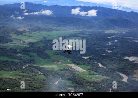 Mikrolichtflugzeuge fliegen über grüne und üppige Naturlandschaften sowie über den berühmten Fluss Kali Progo, Kulanprogo. Stockfoto