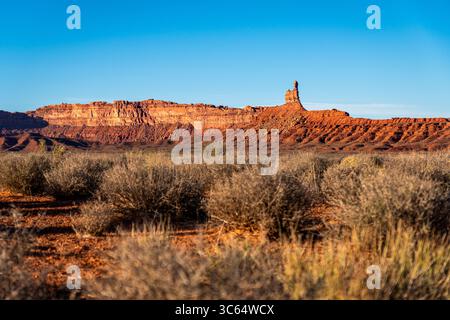 Eine riesige Wüstenlandschaft mit einem majestätischen Berg im Hintergrund, Valley of the Gods Road at Sunset in Utah Stockfoto