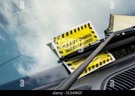 Strafgebühr Parkgebühren, die in London unter dem Scheibenwischer eines Autos angebracht werden. Stockfoto