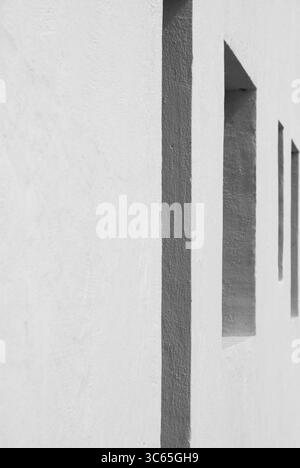 Schwarz-weiß-Bild einer minimalistischen weißen Wand mit eckigen Schatten, die von starkem Sonnenlicht auf der Insel Graciosa auf den Kanarischen Inseln geworfen werden. Ein auffälliger abstrakter Ausdruck Stockfoto