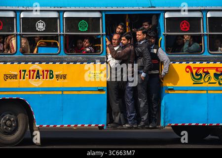 Kalkutta, Indien - 28. Januar 2023: Blick auf die Passagiere, die in einem leuchtend blau-gelben Bus gestaut sind, einem Mikrokosmos des urbanen Lebens in Westbengalen. Stockfoto