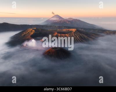 Aus der Vogelperspektive des Bromo-Tengger-Semeru Nationalparks, umgeben von ätherischem Nebel, enthüllt den majestätischen Mount Bromo und Mount Semeru, Cemoro Lawang, Ost-Java, Indonesien. Stockfoto