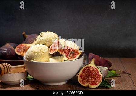 Leckeres Feigeneis, aromatisches und cremiges Fruchtsorbet-Dessert mit herbstlich würzigem Geschmack, in portionierter Schüssel, auf hölzernem Hintergrund mit Whol Stockfoto