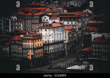 Porto, Portugal - 17. Juni 2022: Blick auf Terrakotta-Dächer, die über alte Gebäude kaskadieren, ein warmer, einladender Kontrast zu den kühlen, schattigen Straßen darunter. Stockfoto
