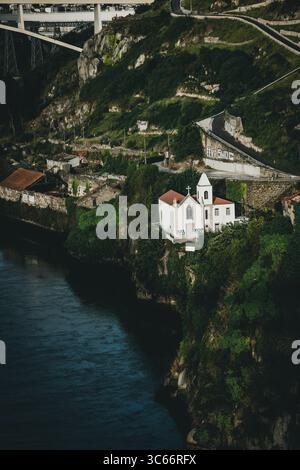Porto, Portugal - 17. Juni 2022: Blick auf die scharf weiße Kapelle, die sich an den grünen Klippen über dem Fluss Douro anmutig im Hintergrund erhebt. Stockfoto