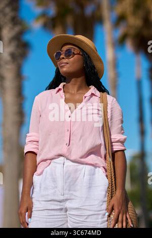 Touristen mit Sonnenbrille und Hut genießen die Sommersonne unter Palmen Stockfoto