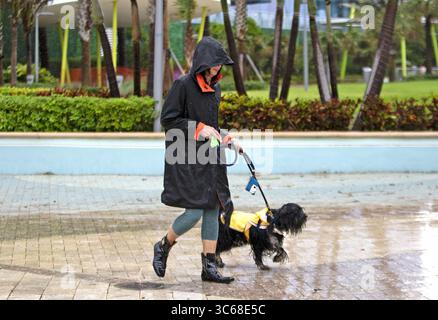 24. Mai 2020, Sunny Isles Beach, FL, USA: Eine Frau mit Hund spaziert im Regen vor dem Samson Oceanfront Park in Sunny Isles Beach am Sonntag, 24. Mai 2020. (Kreditbild: © TNS via ZUMA Wire) Stockfoto