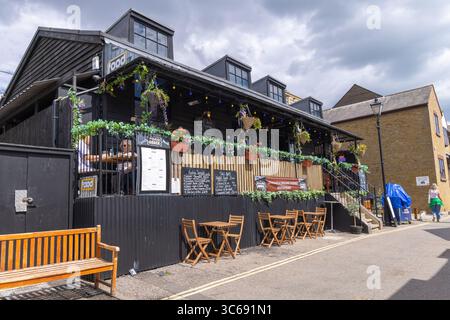 Sitzplätze im Freien im Food Shack t in Leigh-on-Sea, Essex, Großbritannien. Hängende Pflanzen und Lichterketten sorgen für eine gemütliche, einladende Straßenszene. Stockfoto