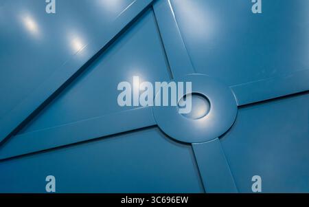 Blaue Wandverkleidung mit geometrischem Muster. Bild mit großem Seitenverhältnis der blauen satinierten Wandplatte, die helle Lichter reflektiert. Stockfoto