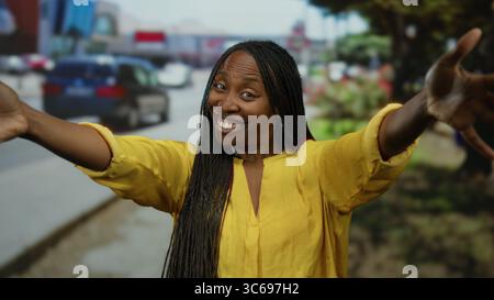 Frau umarmt sich freudig auf einer Stadtstraße und fängt das Wesen des urbanen Lebens mit ihrer leuchtend gelben Kleidung und ihrem entspannten Auftreten ein. Stockfoto
