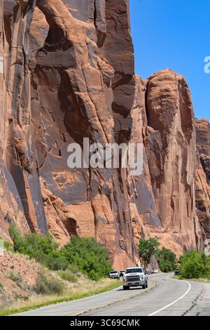 Moab, Utah, USA - 25. Mai 2025: Fahrzeug auf der Potash Road unter riesigen Felsen in der Nähe von Moab Stockfoto