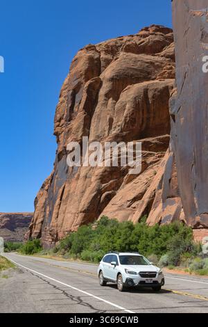 Moab, Utah, USA - 25. Mai 2025: Fahrzeug auf der Potash Road unter riesigen Felsen in der Nähe von Moab Stockfoto