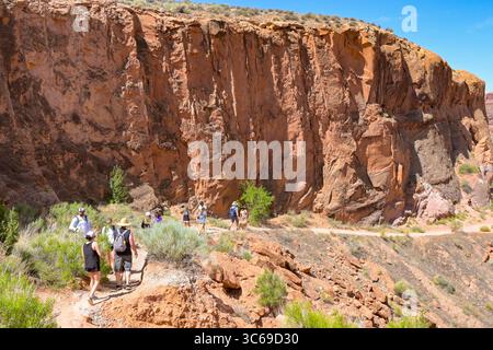 Moab, Utah, USA - 25. Mai 2025: Gruppe von Menschen, die auf einem Pfad über felsiges Gelände in der Nähe von Moab wandern Stockfoto