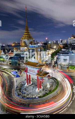Bangkoks Chinatown Gate von oben betrachtet, mit dynamischen Lichtspuren von Fahrzeugen, die sich um den Kreisverkehr drehen Stockfoto