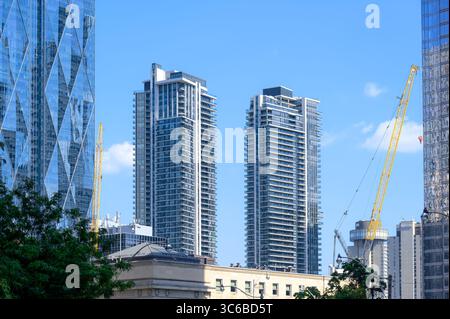 Die Doppeltürme des Maple Leaf Square erheben sich hinter einem historischen Gebäude, umgeben von modernen Glasfassaden und Baukränen. Stockfoto