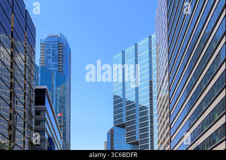Eine Mischung aus Bürotürmen mit Spiegeln und modernen Wohngebäuden säumt einen klaren blauen Korridor im Finanzviertel. Stockfoto