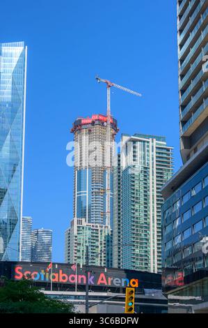 Der Pinnacle One Yonge Turm erhebt sich im Bau hinter der Scotiabank Arena, umgeben von Wohnhäusern. Stockfoto