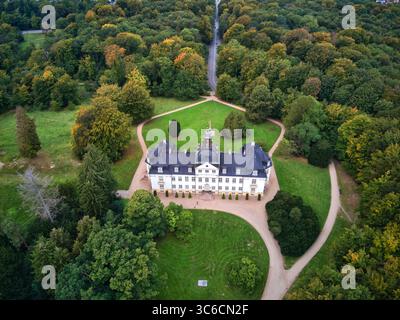 Blick aus der Vogelperspektive auf einen großen, weißen Palast mit dunklen Dächern, umgeben von lebhaften grünen Rasenflächen und üppigen Bäumen, Jægersborg Dyrehave, Gentofte, Dänemark. Stockfoto