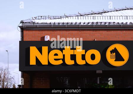 Netto-Logo in einem Geschäft im Winter – Netto ist eine dänische Kette von Discount-Supermärkten im Besitz der Salling Group. Stockfoto