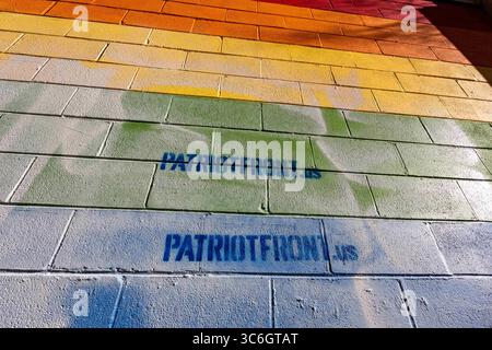 9. Januar 2021, Bellefonte, Pennsylvania, USA: Ein Stolz-Wandbild auf der Außenseite von Jake's Card and Game Shop wurde mit schablonierten weißen nationalistischen Botschaften zerstört. Dutzende von Community-Mitgliedern versammelten sich bei Jake's Cards and Games, um das entstellte Stolz-Wandbild auf der Seite des Unternehmens neu zu malen. Freiwillige übermalten abwechselnd die Spraygemälde der weißen nationalistischen Gruppe Patriot Front. (Kreditbild: © Paul Weaver/SOPA Images via ZUMA Wire) Stockfoto