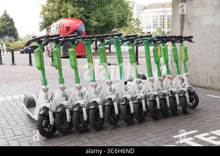 Eine Gruppe von E-Scootern mit Lime-Verleih parkten ordentlich in einer ausgewiesenen Rollerbucht vor dem Eingang zu einer Londoner U-Bahn-Station. UK, Stockfoto