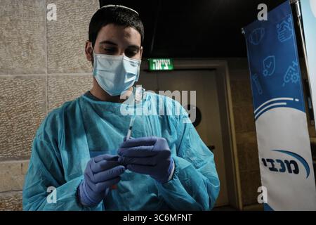 14. Januar 2021, Jerusalem, Israel: Krankenschwestern verabreichen COVID-19-Impfstoffe im Pais Arena Sports Complex in Jerusalem, das in ein Coronavirus-Impfzentrum umgewandelt wurde. Kriterien sind nun entweder Gesundheitspersonal, Erziehungspersonal oder die breite Öffentlichkeit ab 50 Jahren. Die Anzahl der israelischen Bürger, die mindestens eine Dosis des Pfizer BioNTech-Impfstoffs erhalten haben, hat 2 Millionen überschritten, während eine Massenimpfkampagne fortgesetzt wird, und das gilt auch für die COVID-19-Infektion in der Öffentlichkeit. (Bild: © Nir Alon/ZUMA Wire) Stockfoto