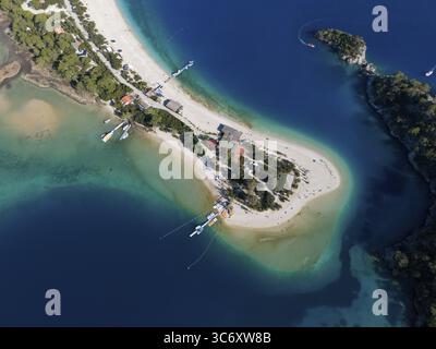 Aus der Vogelperspektive auf eine kleine Insel mit Sandstrand und umliegendem türkisblauem Wasser und Booten, Fethiye, Mugla, Mugla, Ägäis, Türkei Stockfoto