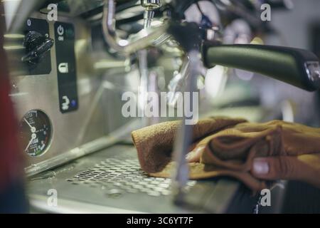 Eine Handreinigung einer Kaffeemaschine in einem Café mit Schwerpunkt auf der Dampfdüse und den Bedienelementen der Espressomaschine, Cremona, Italien, 25. Juli 2025 Stockfoto