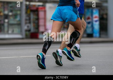 Zwei männliche Athleten laufen nebeneinander in der Stadt Stockfoto