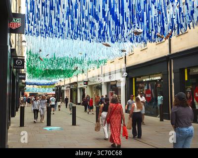 Einkaufsmöglichkeiten im Southgate Shopping Centre, Bath, Somerset, mit Markengeschäften im Blick und blauen und grünen Meeresmotiven über dem Dach. Stockfoto
