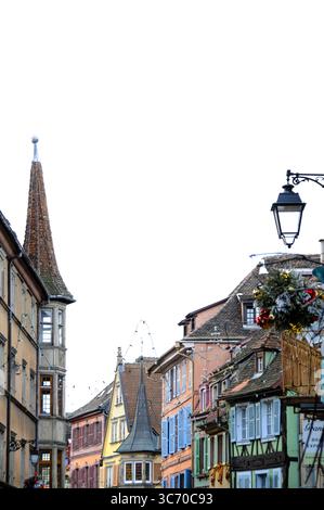 Festliche Weihnachtsdekorationen zieren die farbenfrohen Fachwerkhäuser von Colmar im Elsass. Eine fröhliche Winterszene voller Lichter, Girlanden und Stockfoto