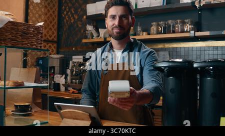Sorglos Kaukasier Guy Unternehmer Besitzer Arbeiter bestellen Kundenzahlung Kauf Gerät Tablet im Café Kleinunternehmen Barista Lächeln Lieferung Stockfoto