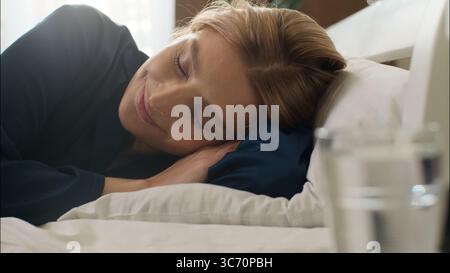 Entspannte verschlafene kaukasische Frau wach Bett Morgen im Schlafzimmer Dame schlafend Sonnenaufgang Gähnen Lazy Mädchen Beginn neuen Tag Komfort glückliche Frau Stockfoto
