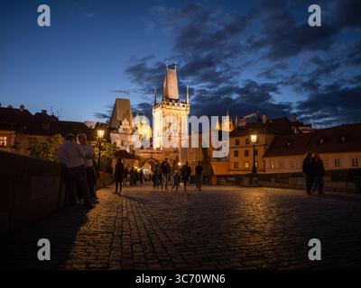 Prager Kleinstädter Brückenturm (Malostranská mostecká věž) am Abend. Beleuchtete Architektur als Reiseziel für Sightseeing. Stockfoto