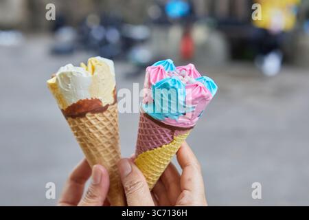 Nahaufnahme einer Hand, die Eis in Waffelkegel hält Stockfoto