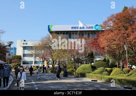 SUWON, SÜDKOREA - 8. APRIL 2023: Menschen laufen in der Nähe des Regierungsgebäudes der Provinz Gyeonggi in Suwon, der Hauptstadt der Provinz Gyeonggi. Stockfoto
