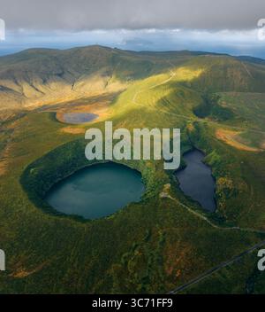 Aus der Vogelperspektive auf Zwillingsseen in vulkanischen Kratern, smaragdgrüne Hügel und dunkles Wasser, das den Himmel reflektiert, Cerrado das Freiras, Sete Cidades, Portug Stockfoto