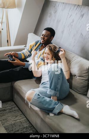 Ein vielseitiges Paar, das zu Hause einen verspielten Spielspaß genießt Stockfoto