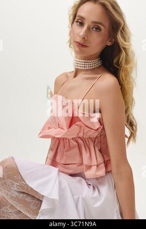 Die blonde Frau posiert elegant und präsentiert ihren schicken Look und ihren fesselnden Stil in einem Fashion Shooting. Stockfoto