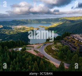Aus der Vogelperspektive auf die Zwillingsseen, die sich in einem vulkanischen Krater eingebettet haben und die Farben des Himmels in der grünen Landschaft reflektieren, Miradouro da Vista do Rei, Sete Cidades, Ponta Delgada, Portugal. Stockfoto