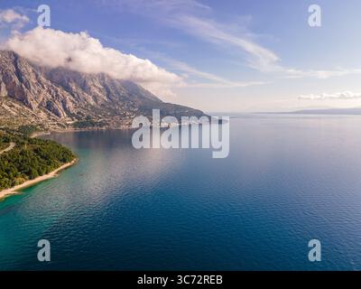 Fantastische Aussicht auf die Strände von Makarska rivera mit Apartments an der Makarska Riviera. Podgora-Caklje Gebiet mit Hochberg Biokovo im Hintergrund. Drohnenansicht. Stockfoto