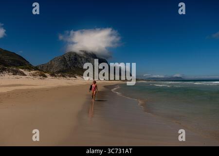 Betty's Bay Februar 2025 Eine Frau, die an einem wunderschönen Strand in Betty's Bay, Bettysbaai, einer kleinen Urlaubsstadt an der Küste von Overberg, Südafrika, spaziert Stockfoto
