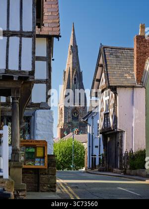 Straßenecke mit Blick auf eine Gasse in Richtung eines entfernten St. Peters Kirchturms in der Stadt Ruthin, Nordwales Stockfoto
