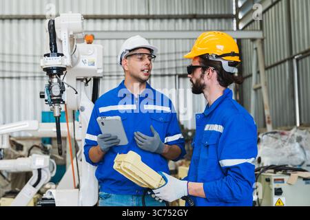 Roboteringenieure überprüfen einen Roboterarm in einer Industriefabrik Stockfoto