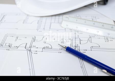 Hintergrund eines architektonischen Entwurfs und Werkzeugs auf einem Tisch, was darauf hindeutet, dass ein Architekt an einem Projekt arbeitet Stockfoto