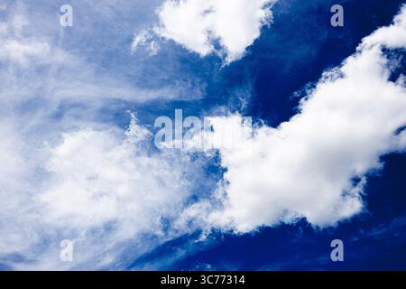 Hellblauer Himmel voller weicher, weißer und schimmernder Wolken. Stockfoto