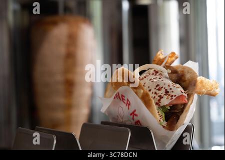 Stuttgart, Deutschland. August 2025. Ein Döner ist vor einem Dönerspieß zu sehen. Der Spieß wurde von der Firma Birtat hergestellt. Quelle: Markus Lenhardt/dpa/Alamy Live News Stockfoto