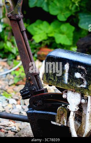 Eine Nahaufnahme eines verwitterten und rostigen Eisenbahnwechselmechanismus mit der sichtbaren Zahl „13“ vor einem unscharfen grünen Hintergrund in Pingxi, New Taipe Stockfoto