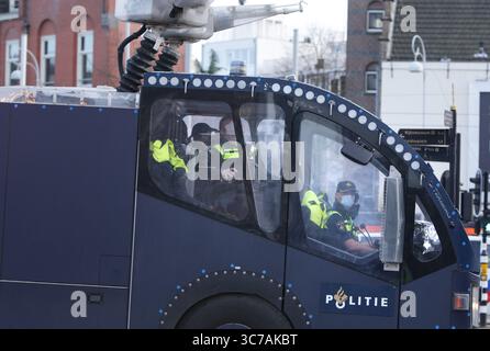 31. Januar 2021, Amsterdam, Niederlande: Niederländische Anti-Aufruhr-Polizisten Wasserkanonen-Fahrzeugteam marschieren vor, um Demonstranten während einer illegalen Demonstration am Museumplein während der Coronavirus-Pandemie am 31. Januar 2021 in Amsterdam zu evakuieren. Die Amsterdamer Bürgermeisterin Femke Halsema stufte den Museumplein als "Sicherheitsrisikobereich" ein und gab Polizeibeamten das Recht, jeden in diesem Bereich zu überprüfen und zu durchsuchen, um illegale Demonstrationen und Vandalismus zu verhindern. (Kreditbild: © Paulo Amorim/VW Pics via ZUMA Wire) Stockfoto